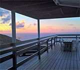 The view from the open-air terrace at Hog Heaven restaurant, Virgin Gorda, looking out on a sunset in the background.