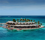 A tiny resort island that is Saba Rock bar and restaurant in the middle of the ocean on a sunny day at North Sound, Virgin Gorda.