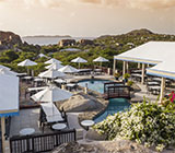 Overhead view of Top of the Baths restaurant in Virgin Gorda with outdoor seating with umbrellas and The Baths in the distance.